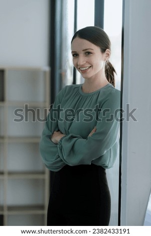 Happy young woman arms crossed standing at office, attractive.