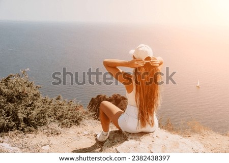 Woman summer travel sea. Happy tourist enjoy taking picture outdoors for memories. Woman traveler posing over sea bay surrounded by volcanic mountains, sharing travel adventure journey