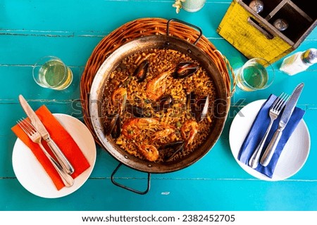 Appetizing racy seafood paella with mussels and prawns traditionally served in metal pan Royalty-Free Stock Photo #2382452705