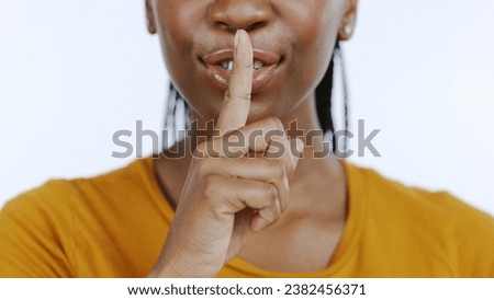 Secret, finger to lips and black woman in studio for privacy, confidential information and face on white background. Mouth zoom, quiet and silence gesture with emoji, gossip or whisper with news Royalty-Free Stock Photo #2382456371
