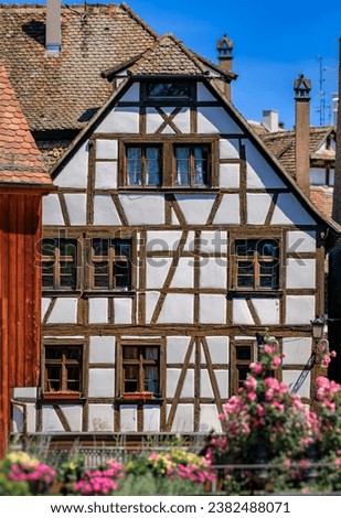 Ornate traditional half timbered houses with blooming flowers along the canals in the picturesque Petite France district of Strasbourg, Alsace, France Royalty-Free Stock Photo #2382488071