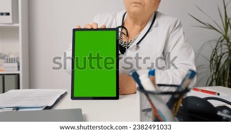 Doctor telemedicine concept use green screen vertical tablet to see the patient and give advice. Technology in healthcare.