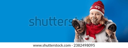 Portrait of a woman with ice skates on a blue background, taking lessons this winter,banner, winter sport