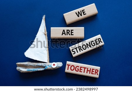 We are stronger together symbol. Wooden blocks with words We are stronger together. Beautiful deep blue background with boat. We are stronger together concept. Copy space.