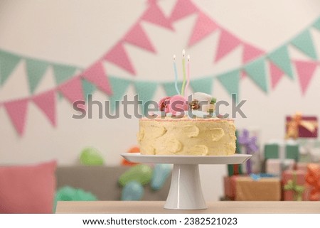 Delicious cake decorated with macarons and marshmallows on wooden table in festive room, space for text