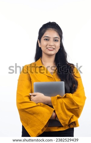 Young Indian, asian business woman, confident female entrepreneur holding laptop wearing professional outfit dress isolated on white background Royalty-Free Stock Photo #2382529439