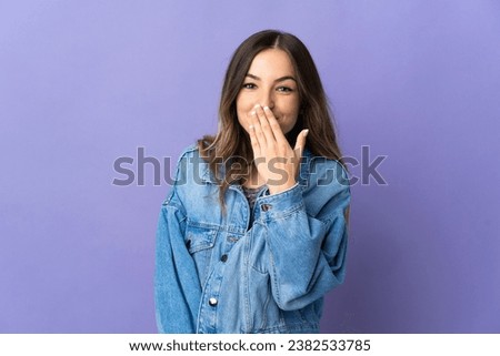 Young Romanian woman isolated on purple background happy and smiling covering mouth with hand Royalty-Free Stock Photo #2382533785