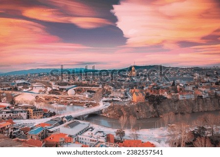 Tbilisi, Georgia. Amazing Cloud Trails In Sky. 6k Georgian Capital Skyline Cityscape. City During Sunset And Night Illuminations. Unusual Cloudy Effects Sky. Elevated Top View Of Famous Landmarks Royalty-Free Stock Photo #2382557541