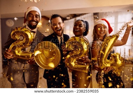 Happy multiracial friends with 2024 golden balloons having fun on New Year's party at home looking at camera. Royalty-Free Stock Photo #2382559035