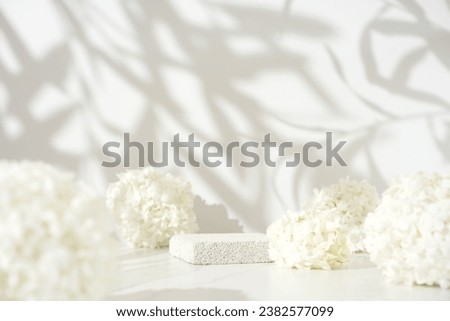 Delicate cosmetics skin care product presentation scene made with pumice stone podium and white lilac flowers