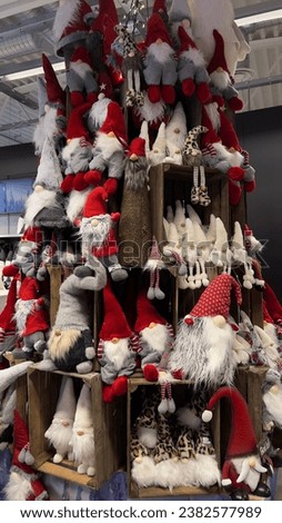 Big tower of Scandinavian Christmas toys, called Tomte. There are many different toy gnomes in a red hats.