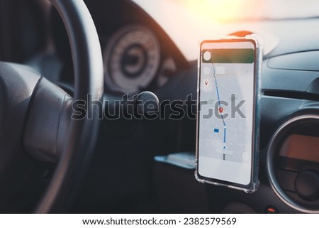 The phone's map appears on the dashboard and street in the background. White cell phone mounted in a mounting with GPS navigation and a map. duplicate the space.