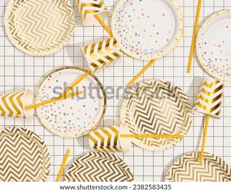 Image of stylish birthday beautiful table setting. Top view of plates, cups and straws.