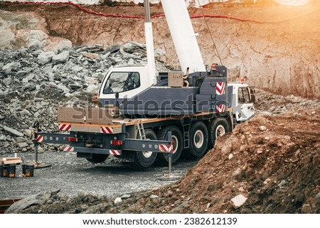 Modern Construction Machinery in Action. View of the mobile crane with a truck. Cable-controlled crane on a truck-type carrier and as self-propelled. Construction site in Europe. Royalty-Free Stock Photo #2382612139