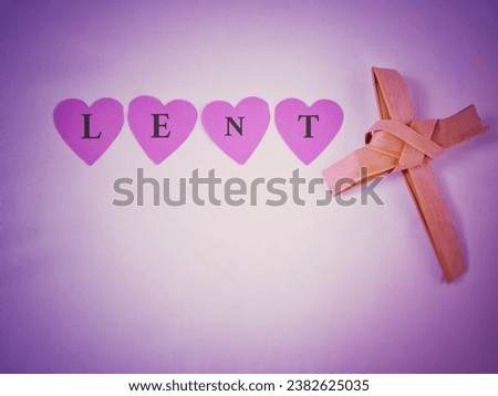 Lent Season, Holy Week, Ash Wednesday and Good Friday concepts - Lent text on heart shaped paper with cross shaped made of palm leaf in purple background. Stock photo.
