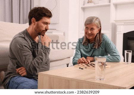 Family playing checkers at coffee table in room