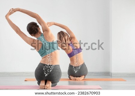 Sporty young women doing yoga in gym. Concept of healthy spine Royalty-Free Stock Photo #2382670903