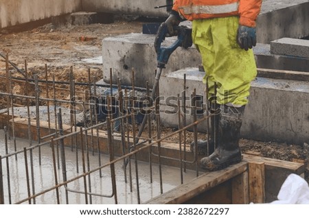 Concrete cast-in-place work. Builder level wet concrete. Concrete works on buildiiing construction site Royalty-Free Stock Photo #2382672297