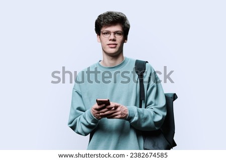 Guy college student with smartphone looking at camera on white background
