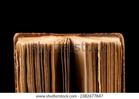ancient book shot on black background. The book is in bad condition. Royalty-Free Stock Photo #2382677847