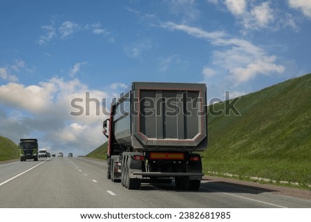 A truck is driving along the highway outside the city. Logistics, transport.