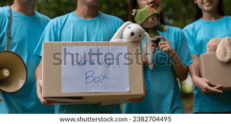 Happy young Asian students diverse volunteers hold donate box and toys for charity to share children and orphanages, a charity for sustainability. Volunteer work lifestyle and social cooperation Royalty-Free Stock Photo #2382704495