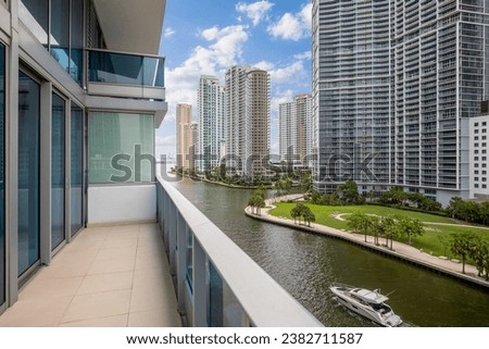 Aerial drone photoshoot Footage in Florida, USA, commercial area, luxury houses, buildings and mansions, abundant tropical vegetation around, blue sky and water canal with boats.