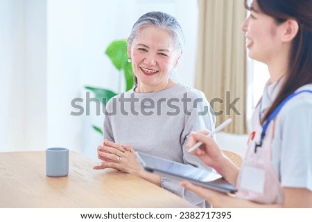 Young woman in apron and senior woman having a conversation at home