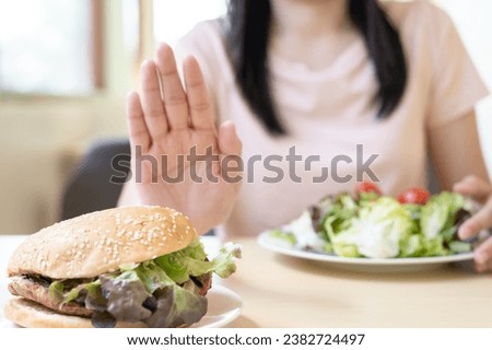 Beauty slim female body confuse hamburger. Woman in restaurant achieves weight loss goal for healthy life, crazy about thinness, thin waist, nutritionist. Diet, body shape. Royalty-Free Stock Photo #2382724497