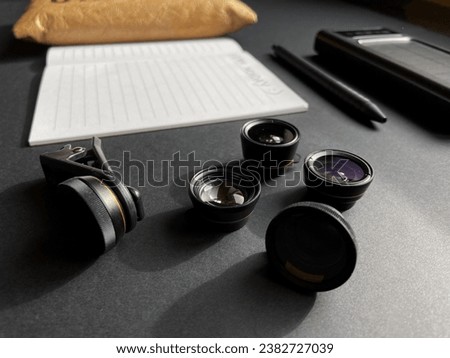 Phone lenses lie on a gray table. A set for the creativity of a mobile photographer on a gray background.