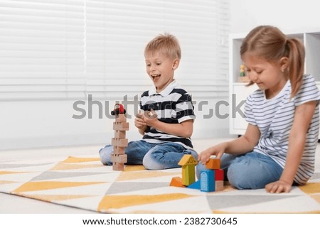 Little children playing with building blocks indoors, space for text. Wooden toys