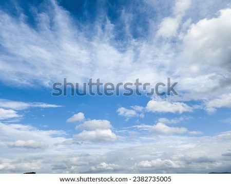 In this close-up photo, cumulus and stratus clouds dance across the sky, their shapes intricate and distinct. Cotton tufts of cumulus clouds intertwine with stratus, smooth expanses of stratus clouds Royalty-Free Stock Photo #2382735005