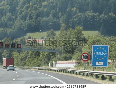 road sign with the text ITALIA htat means ITALY and yellow European stars near the border in the mountains