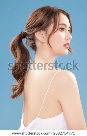 Young Asian beauty woman pull back hair with Koreans makeup style on face and perfect clean skin on isolated blue background. Facial treatment, Cosmetology, plastic surgery. Royalty-Free Stock Photo #2382754971