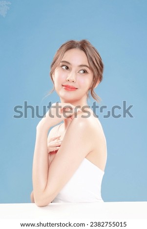 Young Asian beauty woman pull back hair with Koreans makeup style on face and perfect clean skin on isolated blue background. Facial treatment, Cosmetology, plastic surgery.