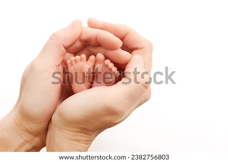 World Prematurity Day on 17th November. Woman hand with a baby feet . Motherhood and care. Royalty-Free Stock Photo #2382756803