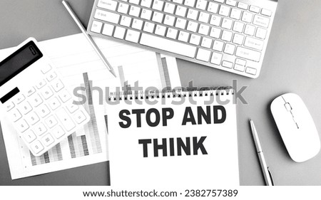 STOP AND THINK text on a notebook with calculator , chart and keyboard business concept