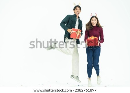 Young Asian couple two friends man woman wearing casual clothes  and holding present red box with gifts together isolated on white background studio portrait. concept new year and christmas gifts.