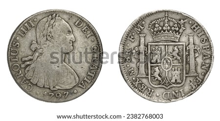 "Pieces of eight". Front and back of Spanish 8-reale silver dollar minted in Mexico in 1797.Worn, tarnished, battered, struck off-center. Was legal tender in most of world (including USA until 1857). Royalty-Free Stock Photo #2382768003
