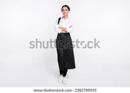 Full length body size photo of confident waitress with crossed hands in black apron isolated on white color background Royalty-Free Stock Photo #2382789019
