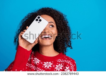 Photo of attractive charming girl curly black hair cover face show samsung iphone gadget look empty space isolated blue color background