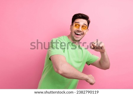 Photo of young funky guy wearing green t shirt boogie woogie discotheque hip hop artist look empty space isolated on pink color background