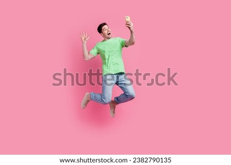 Full body size photo of young man jumping air waving palm greetings self portrait shooting blogger isolated on pink color background