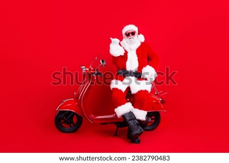 Full size photo of pleasant grandfather wear stylish santa costume sit on moped indicating empty space isolated on red color background