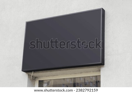 Large black billboard banner on a storefront mockup. Blank black restaurant or shop sign mock up template.