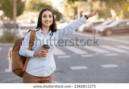 Smiling pretty young european woman with backpack, cup of coffee takeaway, stop taxi with hand sign in city outdoors. Lady enjoy trip, travel tourist, ad and offer, lifestyle