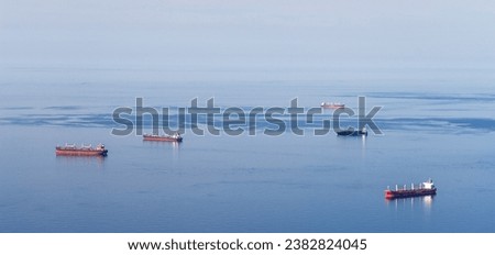 Minimalist picture with just the Mediterranean sea, a blue sky and five cargo boats. Oran, Algeria.