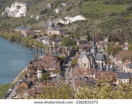 view of the city of Les Andelys, next to the Seine river, with the large roofs of the main church and the palace and current hospital of Saint James from the 17th century Royalty-Free Stock Photo #2382831073