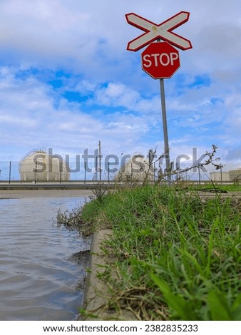 An octacle stop sign on the road sign with cloudy sky background