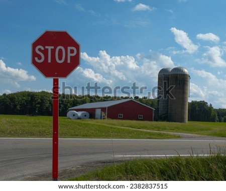 Stop sign with red barn in the background